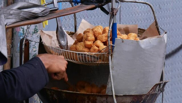 food vendor preparing dish called tahu goreng cripsy or crispy fried tofu