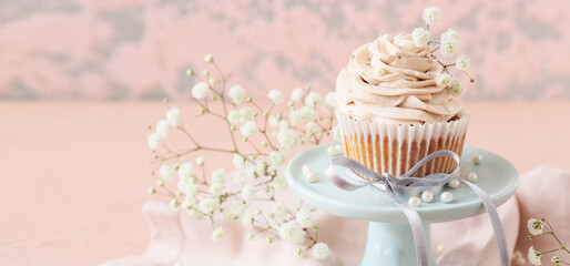 Dessert stand with beautiful wedding cupcake on pink background