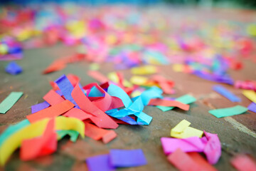 Multicolour paper ticker-tape lies on the ground after celebration of wedding, birthday, carnival, lgbt pride parade or outdoors festival. After party.