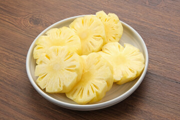 Fresh slices pineapple served in white plate
