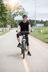 Obraz premium Shot of happy asian guy enjoying biking in the summer park. Sport, leisure and healthy lifestyle concept