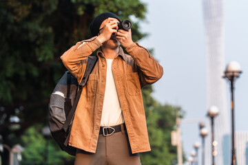 Asian male tourist holding a camera is traveling in the city. 