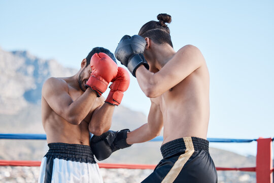 Punch, boxing match or men fighting in sports training, exercise or fist punching with strong power. Fitness action, boxers or combat fighters boxing in practice workout in ring on rooftop in city