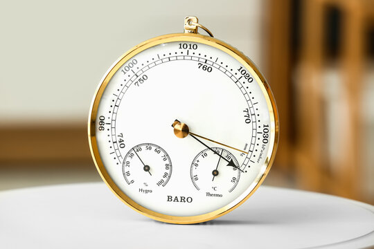 Aneroid barometer on white table in room, closeup