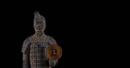 A coin with the symbol of the cryptocurrency bitcoin and a warrior from the terracotta army of the...