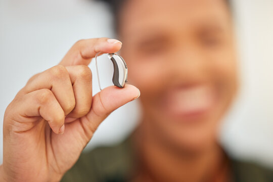 Hearing aid, hands and person with disability for medical support, listening or healthcare innovation. Closeup of deaf patient with audiology implant, amplifier tech or accessory to help sound waves