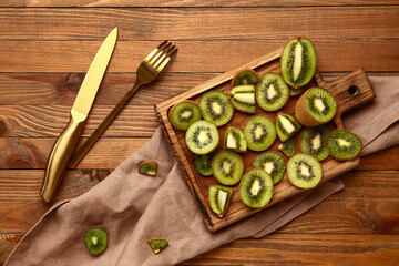 Board with slices of fresh kiwi on wooden background