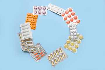 Frame made of different pills on blue background