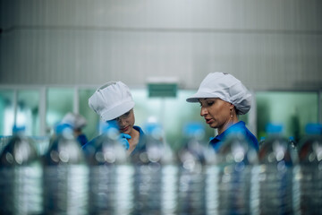 Inspector check conveyor operation with precise bottled water sequencing for seamless production.