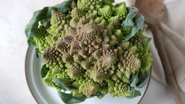 Romanesco broccoli rotating on plate, view from above
