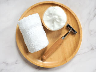 Razor, shaving foam and towel at top view on marble table - lifestyle, wellbeing and zero waste...