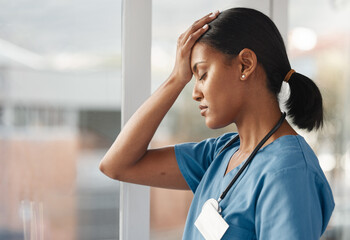 Mental health, doctor with headache and stress standing at window at hospital. Burnout or...