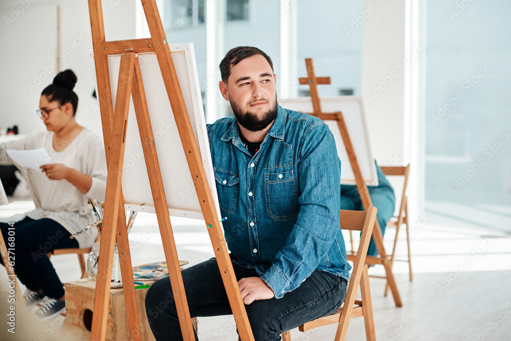 Poster i wonder what colour i should use. cropped shot of a handsome young artist sitting and looking conte