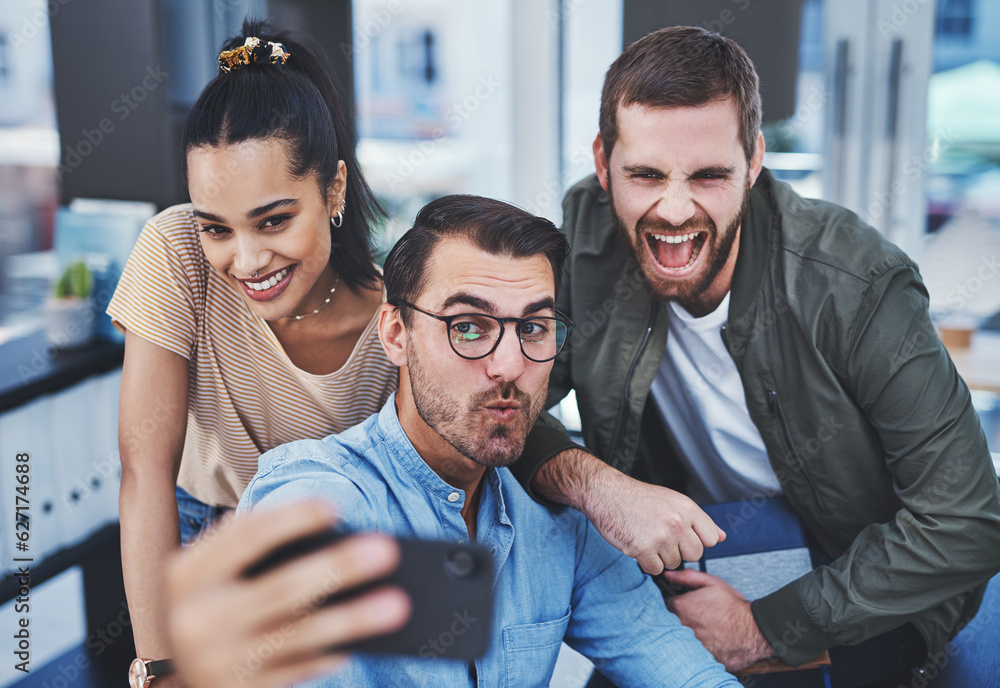 Poster Never a dull moment when this dynamic team are together. Shot of a group of designers taking selfies together in an office.