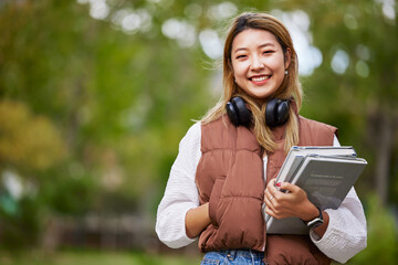 Student with headphones, portrait and woman with books for learning, education and on university...