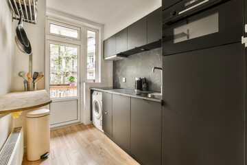a kitchen with wood flooring and black appliances on the wall above the washer, dishwasher and dryer