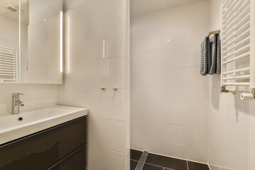 a bathroom with black and white tiles on the walls, along with a sink and mirror in the room is very clean