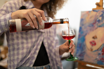holding a bottle of wine and pouring into a glass