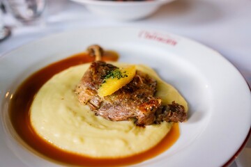 A plate of canard a l’orange (orange duck) — confit duck leg with potato purée and orange sauce — at a French bistro in Circular Quay, Sydney. New South Wales, Australia