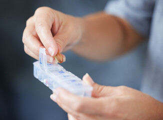 Hands, container and routine medicine with a woman in her home during retirement closeup for daily vitamins. Healthcare, medical and supplements with an elderly person taking prescription medication