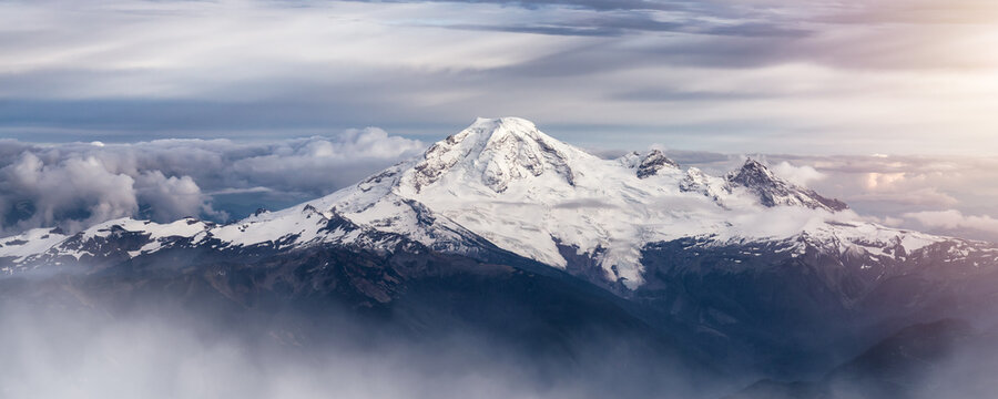 Mt Baker covered in snow and clouds. Aerial landscape nature background.