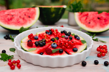 Fruity watermelon pizza with seasonal fruits on the garden table