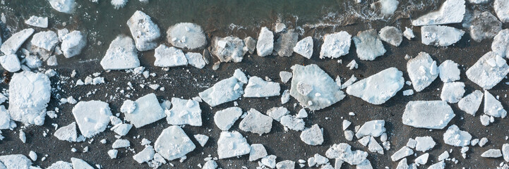 Top view of the ice floes on the shore. Aerial view of melting ice on the sea coast. Climate change...