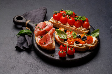 Sandwich set of bruschetta with juicy tomatoes, cheese and prosciutto