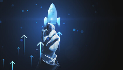 Close up of man hand pointing at glowing flying blue rocket on dark background with mock up place. Start up and launch concept.