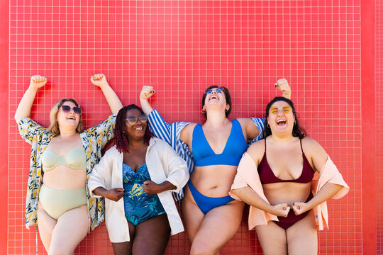 Group of plus size women with swimwear at the beach - Multiethnic curvy adult female having fun and sunbathing on summertime vacation, concepts about beauty, body positivity and self acceptance