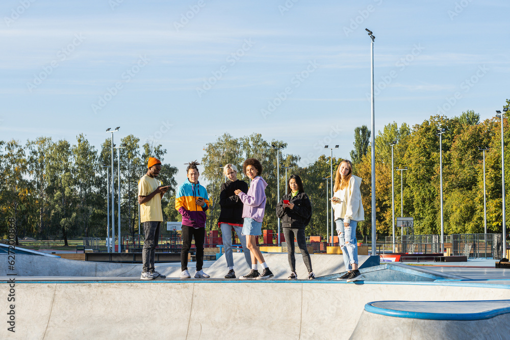 Wall mural Multiracial group of young friends bonding outdoors