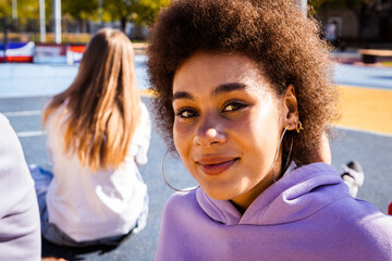 Multiracial group of young friends bonding outdoors, portrait of beautiful black hispanic young...