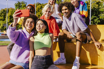 Obraz na płótnie Canvas Multiracial group of young friends bonding outdoors
