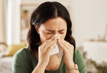 Tissue, nose and sick woman sneezing on a sofa with allergy, cold or flu in her home. Hay fever,...