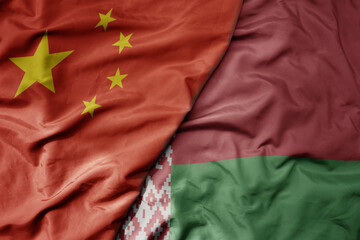 big waving national colorful flag of china and national flag of belarus .