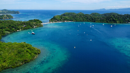 Tropical islands in the Pacific Ocean. Aerial view of the islands, beach and boats in the bay.