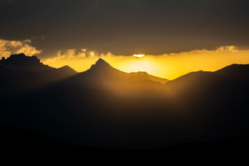 Beautiful fiery sunset. The sun goes down the mountain