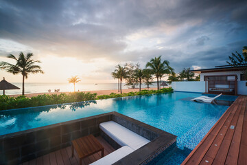 Summer vacation at poolside. Veranda decorated with deck chairs and umbrella with an ocean view