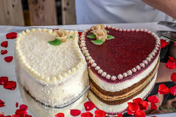 Romantic wedding Two cakes in heart shape, roses bouquet on white table background. Top view