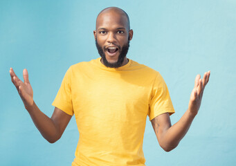 Portrait, wow and surprise with a black man in studio on a blue background feeling shocked or in...