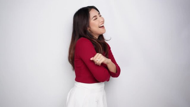 Young happy Asian woman dancing having fun alone isolated by white background