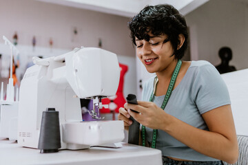 latin woman seamstress, dressmaker or fashion designer working with a sewing machine at her workshop in Mexico Latin America, Hispanic small business owner female