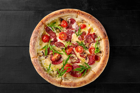 Boscaiola pizza with mozzarella, cabanossi, salami, mushrooms, parmesan and arugula