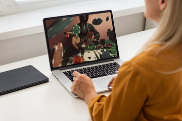 Attractive young woman looking totally happy and excited about money win after making bets online at bookmaker's website using mobile application on her phone.