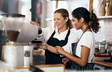 The skill behind the coffee that you love so much. Shot of two women preparing coffee in a cafe.