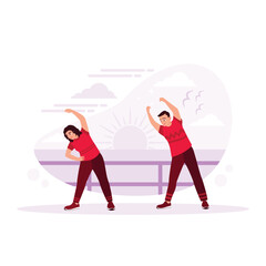 two young friends, men in tracksuits, warm-up exercises, doing stretching exercises on the sand sea, jogging outdoors by the sea on a summer morning. Couple warming up against a beach background.