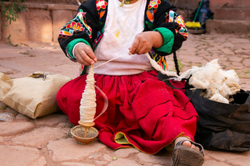 Indigenous woman working on the elaboration of textile handicrafts in a community on Lake Titicaca, Peru. - obrazy, fototapety, plakaty
