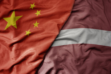 big waving national colorful flag of china and national flag of latvia .