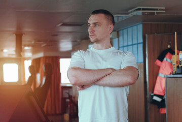 Deck officer on the bridge during navigational watch at sea. Offshore technician. Seafarer. Seaman. Navigator. A man in the wheelhouse. Cargo officer. Chief mate on board container vessel. © I am from Mykolayiv