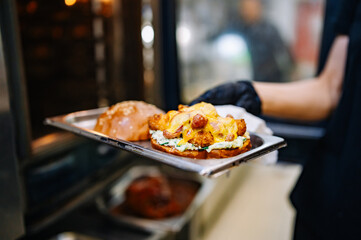 chef hand cooking cheese burger in oven on restaurant kitchen